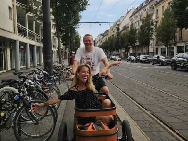 Couple souriant avec le triporteur minica sur une avenue de Strasbourg