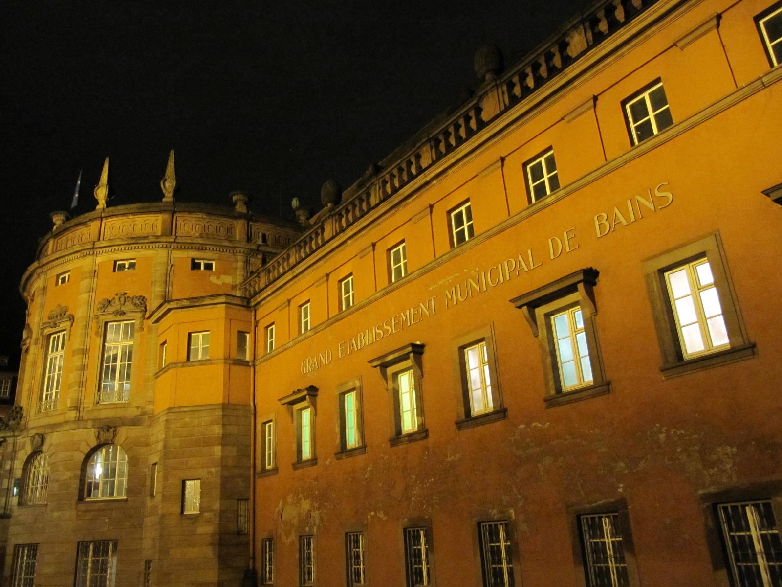 Fritz Beblo's Bains Municipaux, lit up at nightfall