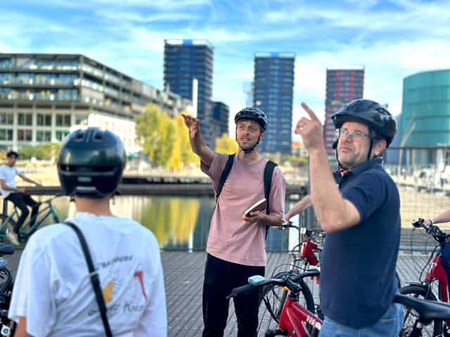 Un accompagnateur montre l'architecture contemporaine de Strasbourg à un groupe à vélo